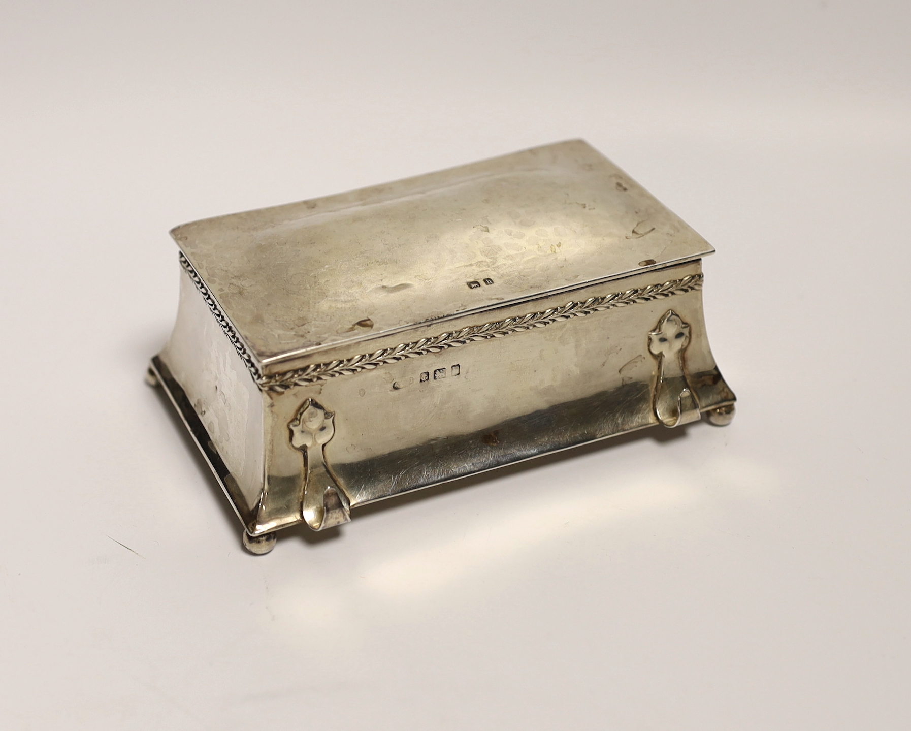 An Edwardian Arts and Crafts silver inkwell by Albert Edward Jones, with front pen rest and interior engraved inscription, Birmingham, 1907, 13.3cm.